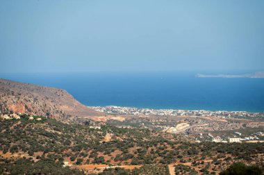 Girit 'teki sahil şeridinin çarpıcı manzarası, mavi denizi ve yakındaki köyleri gösteriyor..