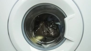 Çamaşır makinesinin içinde giysiler olan kapısının hareketini durdur. 