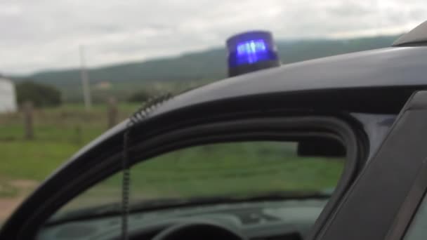Vista exterior primer plano de una luz intermitente azul de la policía en el techo del coche — Vídeo de stock