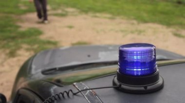 Tutuklanan bir kızın arka planında mavi polis ışığı yanıyor.