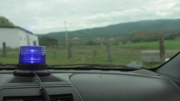 Blauw politie knipperend licht op met de achtergrond van een meisje wordt gearresteerd — Stockvideo