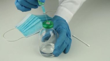 Mavi eldivenli doktorun elleri covid 19 aşısını incelemek için tıbbi örnek.