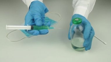 Mavi eldivenli doktorun elleri covid 19 aşısını incelemek için tıbbi örnek.
