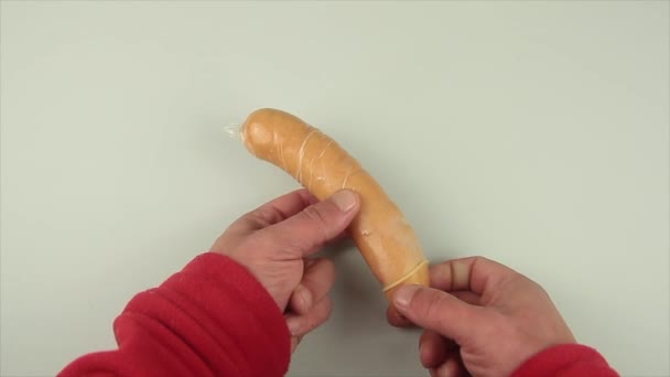 Le mani di uomo che toglie il preservativo da una salsiccia come rappresentazione d'insegnamento sessuale — Video Stock