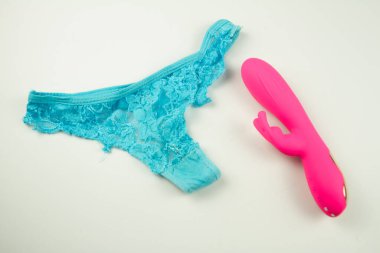 Kadın pembe seks vibratörünün yanındaki tanga.