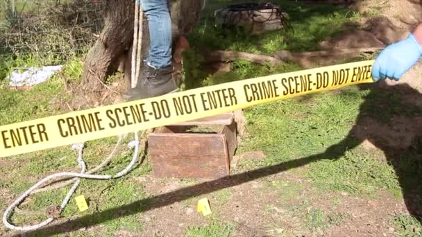 Csi detective in front of the hanged dead man feet hanging from a tree — Stock Video