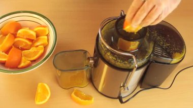 Yukarıdan görülen havuçları sıkan portakal suyu çıkarıcı çalışıyor.