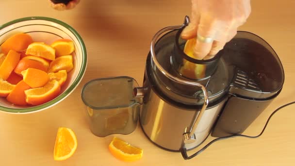 Экстрактор апельсинового сока в работе, который выжимает морковь сверху — стоковое видео