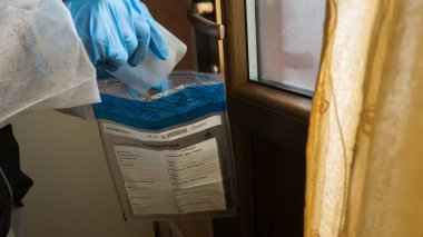 Olay yerindeki olay yeri inceleme dedektifi mavi fenerlerle inceleme yapıyor ve bir cinayetin işlendiği evin kapı kolundan alınan laboratuvara bilimsel kanıtlar götürüyor.