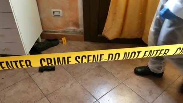 Vyšetřovatel CSI na místě činu, který kontroluje s modrými baterkami a bere vědecké důkazy, aby je odvezl do laboratoře z kliky dveří domu, kde byla spáchána vražda. — Stock video