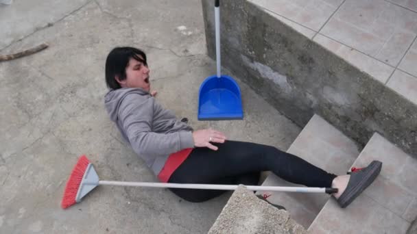 当一个白人女孩用扫帚 垃圾桶和水桶从梯子上摔下来的时候 她在打扫家用房屋时发生意外 — 图库视频影像