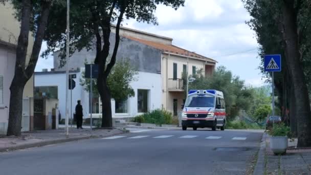 Ambulance v případě nouze s blikajícími světly pomalu projíždějící městem — Stock video