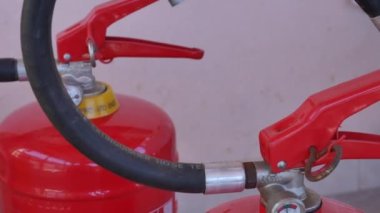 Bir yangın söndürücünün boş olduğunu gösteren kapakçık ve basınç göstergesi olan iki yangın söndürücüyü yakın plan kaydır.