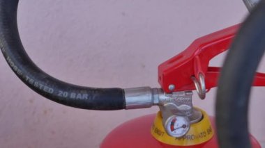 Bir yangın söndürücünün boş olduğunu gösteren kapakçık ve basınç göstergesi olan iki yangın söndürücüyü yakın plan kaydır.