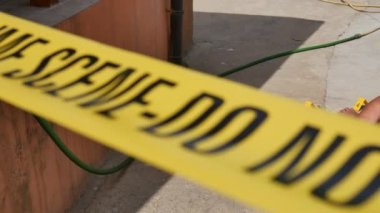 Adli tıp müfettişi olay yerinde yerde yatan ölü bir erkekle birlikte ateşli silah topluyor.