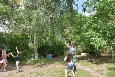 children playing with blowing bubbles in the park