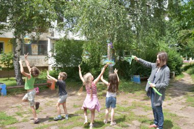 children playing with blowing bubbles in the park
