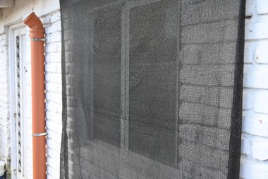 Beyaz tuğla duvardaki siyah örtü penceresi