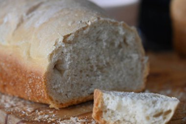 Tahta kesme tahtasıyla dilimlenmiş taze pişmiş ekmek.