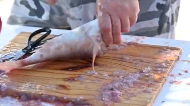 Balıklar masada bıçak ve balık makasıyla temizleniyor.,