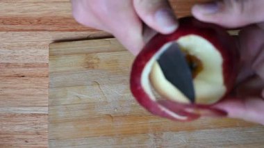 Kırmızı elma kabuğu dilimlerle ahşap yüzeyde duruyor.