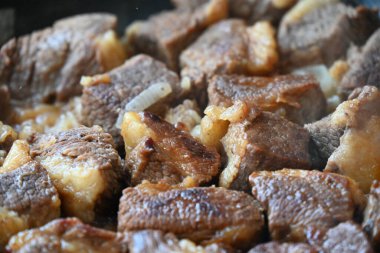 Tavada pişmiş et parçaları.