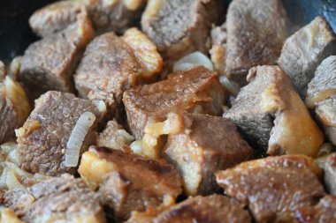 Tavada pişmiş et parçaları.