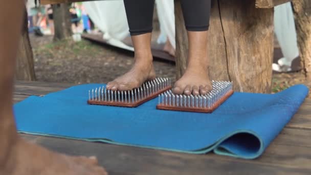 Kvinnors fötter står på en bräda med vassa naglar, Sadhu Board — Stockvideo