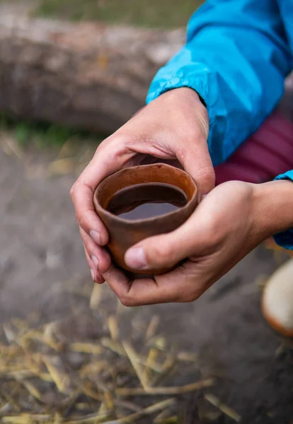 キャンプファイヤーの近くで中国茶PuのErhの屋外を飲むEcovillageでオーブン。小さな木製のテーブルの上にクレイティーポット、カップとポット — ストック写真