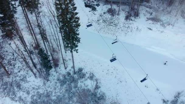 Vista aérea do drone em elevadores de cadeira para esquiadores e snowboarders no dia ensolarado em montanhas dos Cárpatos, Ucrânia, Bukovel — Vídeo de Stock