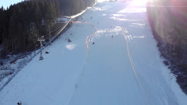 Drohnenblick auf Sessellifte für Skifahrer und Snowboarder bei sonnigem Tag in den Karpaten, Ukraine, Bukovel — Stockvideo