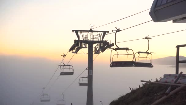 Sedia Ascensore Spostarsi sulla cima della montagna chiara Al tramonto Escalation dalla nebbia. Foggy Day nella località sciistica di Bukovel, Carpazi, Ucraina — Video Stock