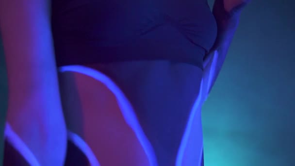 Retrato de una chica con rastas en neón UF Light. Chica modelo con maquillaje psicodélico creativo fluorescente, diseño artístico de modelo de bailarina de disco femenina en UV, maquillaje abstracto colorido. Dama bailando — Vídeo de stock