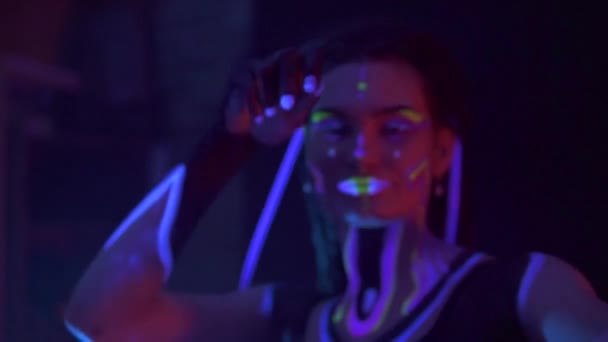 Ritratto di una ragazza con paraocchi al neon UF Light. Modello Ragazza con Fluorescente Creativo Trucco Psichedelico, Art Design di Femmina Disco Dancer Modello in UV, Colorato Trucco Astratto. Signora danzante — Video Stock