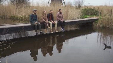 Dört Neşeli Arkadaş Grubu Hollanda 'nın Kinderdijk kentindeki köprüde oturan ördekleri besliyor.