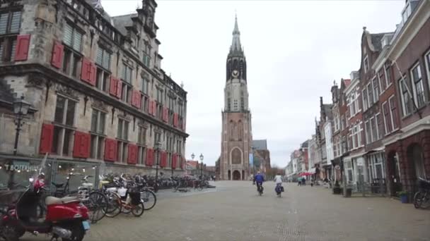 DELFT, NEDERLAND - MAART 2020: Mensen lopen op het centrale plein omringd door oude huizen — Stockvideo