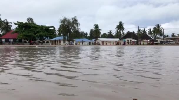 ZANZIBAR, TANZANIA - JANUARI 2020: Byborna spelar fotboll nära Big Paddle efter regn i grundläggande miljö på Village Center Square — Stockvideo