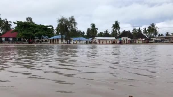 ZANZIBAR, TANZANIA - GENNAIO 2020: Gli abitanti del villaggio giocano a calcio vicino a una grande pagaia dopo la pioggia nell'ambiente di base sulla piazza del centro del villaggio — Video Stock