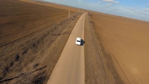 Sportovní dron FPV s akční kamerou sleduje Old Soviet Car Volga 24 na Osamělé silnici mezi hnědými poli. Fpv Racing drone first Person cinematic chase view. — Stock video