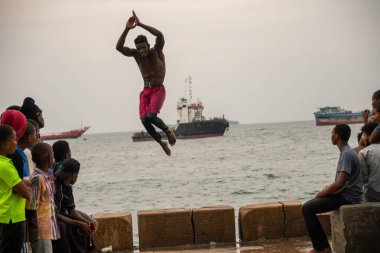 Stone Town, Zanzibar, Tanzanya - Ocak 2020: Yerel halk Zanzibar 'ın ana şehrinde Stone Embarkment' tan denize atlayıp kaçtı