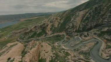 Yılan gibi dar bir yolun havadan görünüşü. Doğu Türkiye 'de viraj ve virajlarla dolu bir yol Hasankeyf. FPV yarış İHA 'sında havadan serbest akrobatik görüntü.