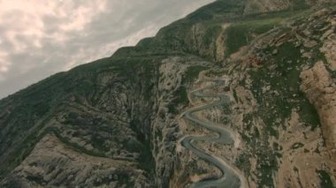 Yılan gibi dar bir yolun havadan görünüşü. Doğu Türkiye 'de viraj ve virajlarla dolu bir yol Hasankeyf. FPV yarış İHA 'sında havadan serbest akrobatik görüntü.