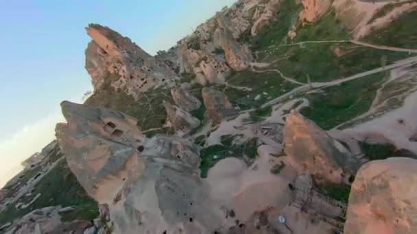 Avanzamento aereo drone filmato Extreme Fast volare tra camini fata rivelando molte case grotta scolpite nella montagna hoodoo Uchisar, Turchia. Filmato in uscita girato con drone da corsa FPV Aerobatico — Video Stock
