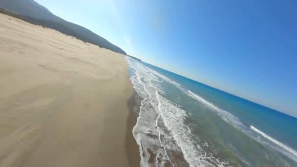 Filmación aérea dinámica en FPV Drone Volando por encima de la playa de arena ancha y larga vacía y Ocean Surf. Olas marinas en la playa de Patara en Likya, Turquía. — Vídeo de stock