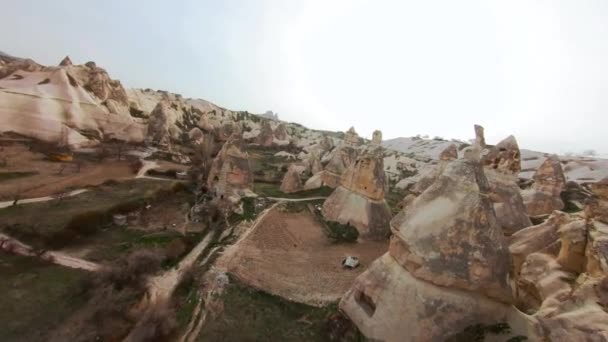 Avanzando riprese aeree drone volare tra camini fatati rivelando molte case grotta scolpite nella montagna hoodoo sopra Valle dei Piccioni e Cappadocia paesaggio naturale a Goreme, Turchia. — Video Stock