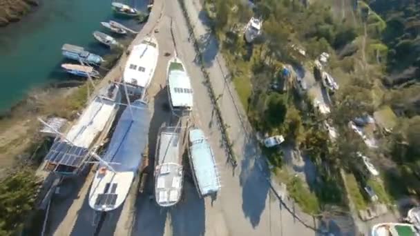 Epic Fast Dynamic FPV drone πλάνα στο λιμάνι κοντά στη Demre της Τουρκίας, Likya. Μικρά μηχανοκίνητα σκάφη στο ποτάμι και τα μεγάλα ιστιοφόρα πλοία στο έδαφος σε αναμονή για μια θερινή περίοδο — Αρχείο Βίντεο