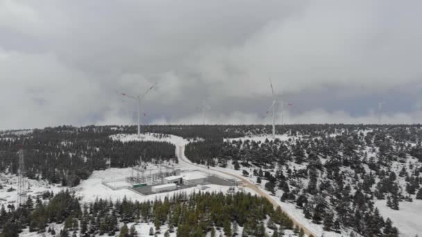 Filmato aereo drone di turbine eoliche sulla cima della montagna coperto di neve nel mese di aprile in Turchia, Panfilia. — Video Stock