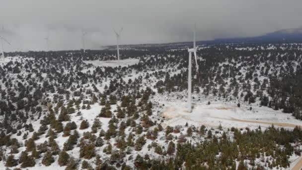 Aerial Drone Filmación de turbinas eólicas en la cima de la montaña Cubierto de nieve en abril en Turquía, Pamphylia. — Vídeo de stock