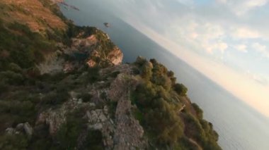 Dynamic Fast Drone Aerial shot od Ancient Antiochia Castle Ruins on the Top of Cliff 'te Akşam Saati' nde kayaların çerçevelediği güzel bir Antakya reklam Cragum lagününün yanında. Havadan serbest akrobatik görünüm