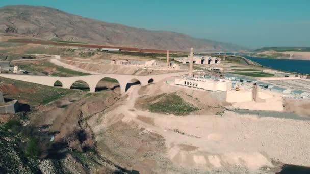 Tiro aéreo da antiga ponte romana restaurada em Hasan Keyf, Turquia. Aldeia Hasankeyf no sudeste da Anatólia. Vista aérea da Fortaleza no Rio Tigre. 12.04.2021 — Vídeo de Stock